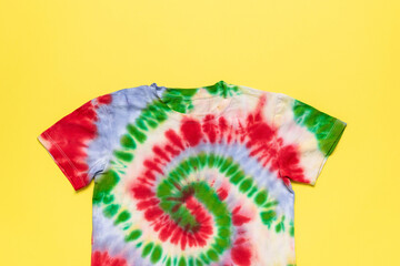 Colorful Tie-Dye T-Shirt on Vibrant Yellow Background - Trendy Fashion, Summer Style, Retro Design