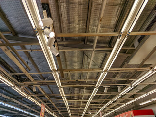 The ceiling of the warehouse showcases a robust iron framework. Suspended from the grid are various...