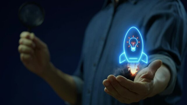 Startup concept, a newly formed business with particular momentum behind it based on perceived demand for its product or service. Businessman shows spaceship icon with lightbulb on virtual screen.