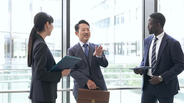 ロビーで会話する多国籍ビジネスパーソンのグループ