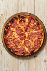Tasty pepperoni pizza on wooden table, top view, copy space