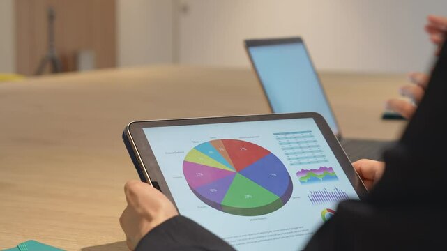 タブレット画面を見ながら会議するビジネスパーソン