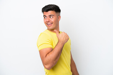 Young caucasian handsome man isolated on white background pointing to the side to present a product