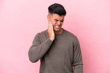 Young caucasian handsome man isolated on pink background with toothache