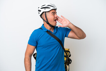 Young caucasian man with thermal backpack isolated on white background shouting with mouth wide open to the lateral