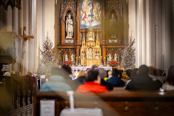 Church altar during Christmas Mass with The Nativity scene. Back view of sitting parishioners. The Catholic Orthodox Christmas holiday in Europe