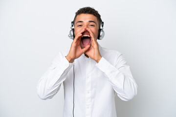 Telemarketer Brazilian man working with a headset isolated on white background shouting and...