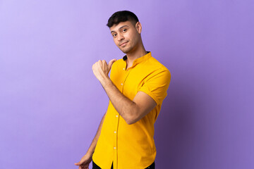 Young Colombian man isolated on purple background proud and self-satisfied