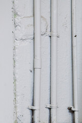 Metal steel pipes on a white rustic wall