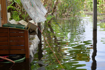 Floodwaters on the garden and into the house almost reaches the wooden bed, the floor submerged underwater — damage caused by the forces of nature