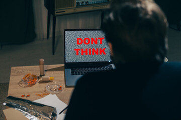 Shaping Worldview: Man Stares at Laptop Screen with 'Don't Think!' Message