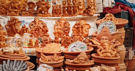 Statues Of Buddha Head And Ganesha On Market. Popular Souvenirs From India. selling pots, vases and other Oriental Ceramic Traditional Handmade Clay dishware Jugs On The Main Bazar market place