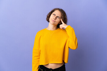 Young English woman isolated on purple background making the gesture of madness putting finger on the head