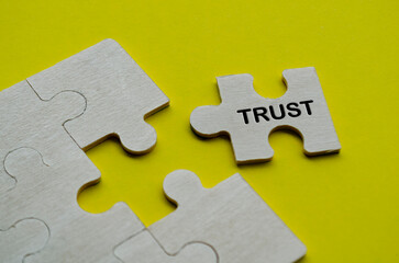 Trust text on wooden separated wooden jigsaw puzzle. Team work and trust concept