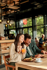 Enjoying a delightful brunch together at a cozy cafe on a sunny afternoon in the heart of the city