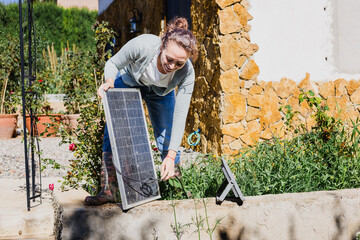 Carbon neutrality : lady holding photovoltaic panel. Sustainability concept