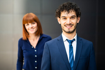 Young businessman smiling with manager in background