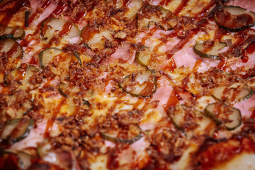 A delicious pizza topped with thin slices of prosciutto, melted cheese, and caramelized onions on a crispy golden crust. The rich colors and textures highlight the mouth-watering ingredients.