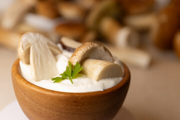 Creamy mushroom sauce in wood pot. Sour cream with mushrooms. Mushroom sauce with porcini chunks