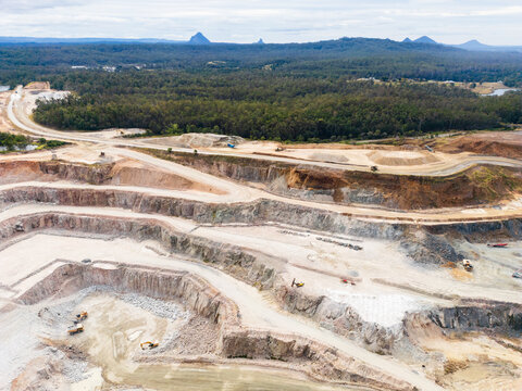 Aerial view over a quarry pit with the Glasshouse Mountains in the background