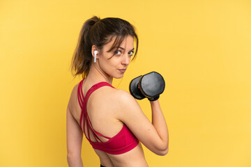 Young caucasian woman isolated on blue background making weightlifting