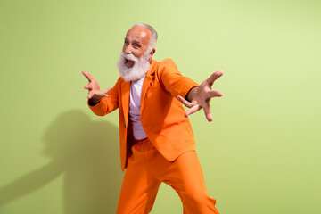 Photo of funny extravagant man entertain dance sing wear orange suit isolated on green color background