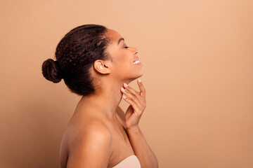 Photo of gorgeous cheerful woman profile touch soft neck naked shoulders isolated on beige pastel...
