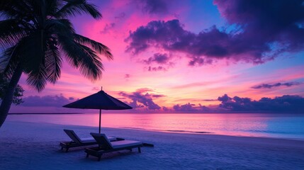 Obraz premium Lovely tropical sunset view with two sun loungers, an umbrella, and palm trees. White sand, a vivid twilight sky, a view of the sea and the horizon, serenity and relaxation. Awe-inspiring beach resort