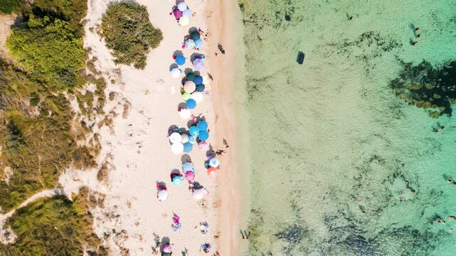 La magia dell'estate a San Pietro in Bevagna: spiaggia, acque turchesi e ombrelloni colorati visti dal cielo - Taranto, Manduria, Salento, Puglia, Italia