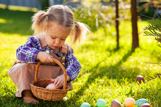 Toddler in backyard on Easter morning hunting for eggs