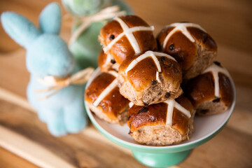 hot cross buns piled up with bunny decorations in the background