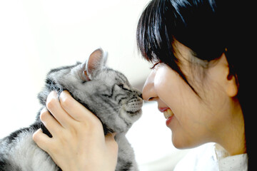 猫と触れ合うアジア人の若い美しい女性 © koumaru
