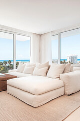 Fototapeta premium Bright and airy living room with large windows overlooking the beach during a sunny day
