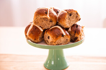 hot cross buns piled up on a green stand ready to eat