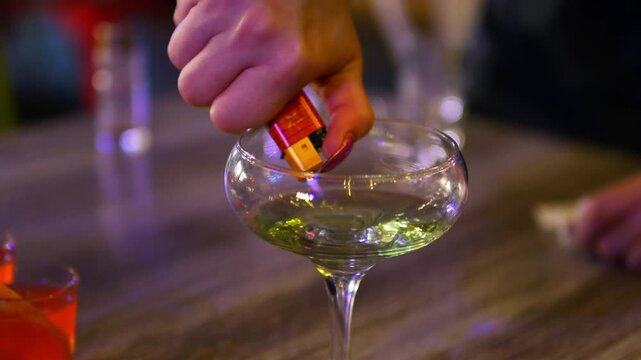 Making process of Burning cocktail absinthe by woman bartender in bar. Nightlife entertainment