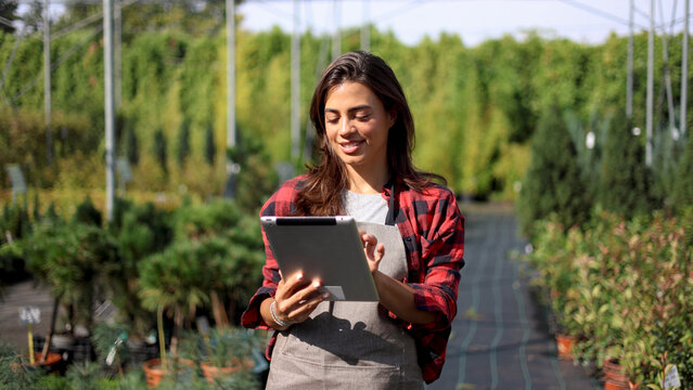 Female agricultural engineer using a digital tablet and planning planting at the garden center