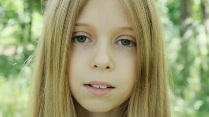 Fototapeta premium Portrait of a girl with long hair against the backdrop of park.