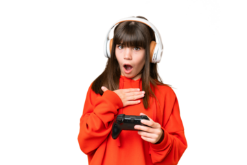 Little caucasian girl playing with a video game controller over isolated background surprised and shocked while looking right