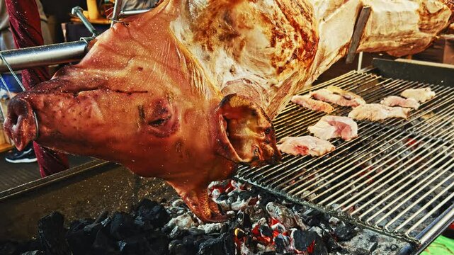 Close-up of Whole Pig Roasting on a Spit Over Open Fire at a Barbecue