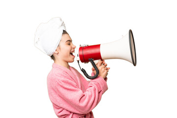 Little girl in a bathrobe over isolated chroma key background shouting through a megaphone