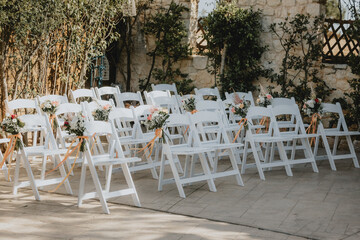 Stuhlreihen für eine freie Trauung einer Hochzeit draußen mit Blumenarrangement