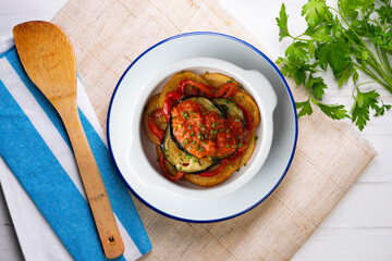 Mallorquin Tumbet. Roasted vegetables with tomato sauce. Top view table with  decoration.