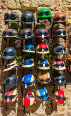 A multitude of different coloured motorbike helmets and sunglasses