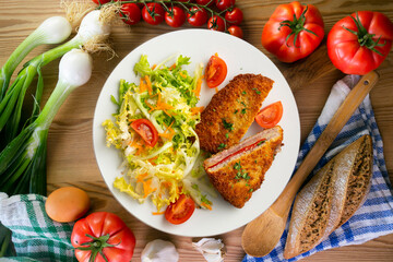 Asturian Cachopo. Breaded beef fillet stuffed with cheese and pepper. Top view table with  decoration.