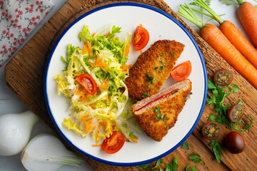 Asturian Cachopo. Breaded beef fillet stuffed with cheese and pepper. Top view table with  decoration.