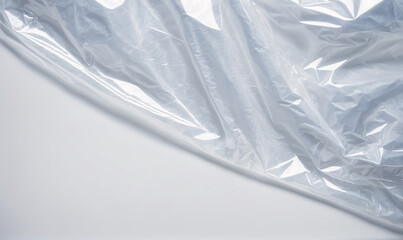 Fototapeta premium A close-up of clear plastic wrap, crumpled and draped over a white surface