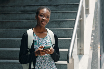 Portrait of African American student using her mobile phone outdoors