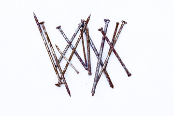A small pile of rusty nail isolated on a white background. they are old, but still can be used for work. with line and hash tage 1inches and other size iron nail with old Pile of metal nails on white 