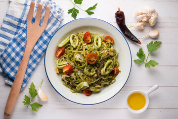 Italian noodles with pesto sauce and squid. Top view table with  decoration.