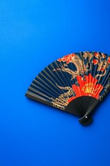 Decorative Chinese fan with dragon motif on blue background